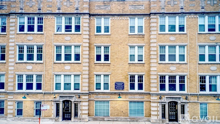 A tall brick building with many windows and doors.