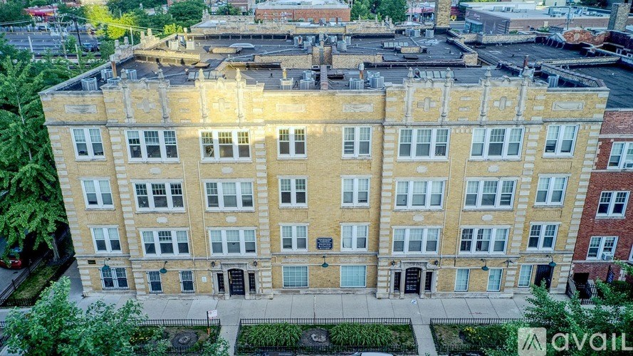 A large, multi-story building with a flat roof and a mix of brick and stone exterior.