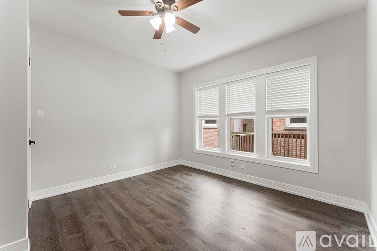 A room with a ceiling fan and a window with blinds.