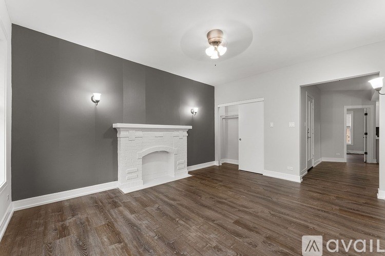 A room with a fireplace and wood flooring.