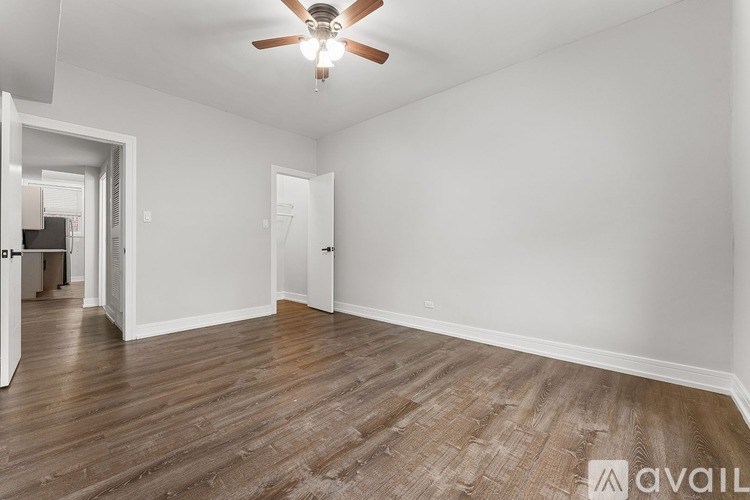 A room with a ceiling fan and wooden flooring.