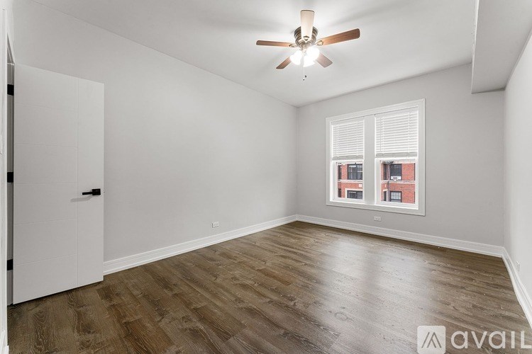 A room with a ceiling fan and wooden flooring.