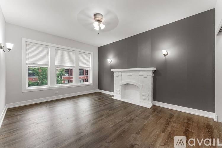 A room with a fireplace and a window with blinds.