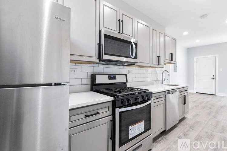 A kitchen with a stainless steel refrigerator, microwave, and stove.