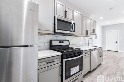 A kitchen with a stainless steel refrigerator, microwave, and stove.