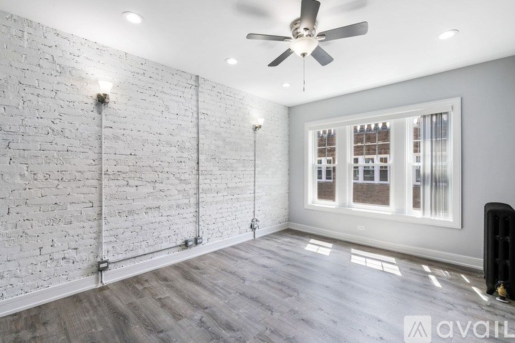 A room with a white brick wall and a ceiling fan.