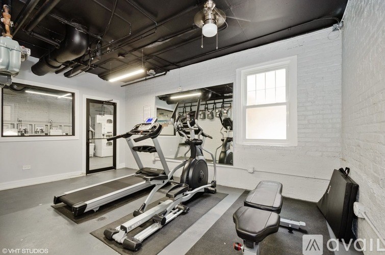 A gym room with treadmills, exercise bikes, and a bench.