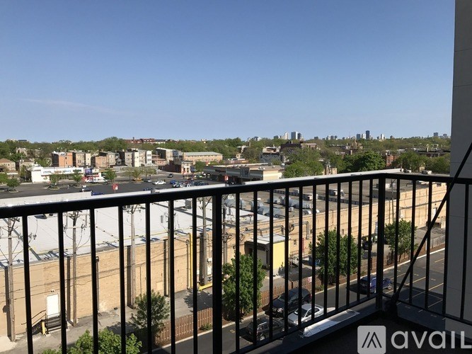 A balcony view of a cityscape with buildings and cars.