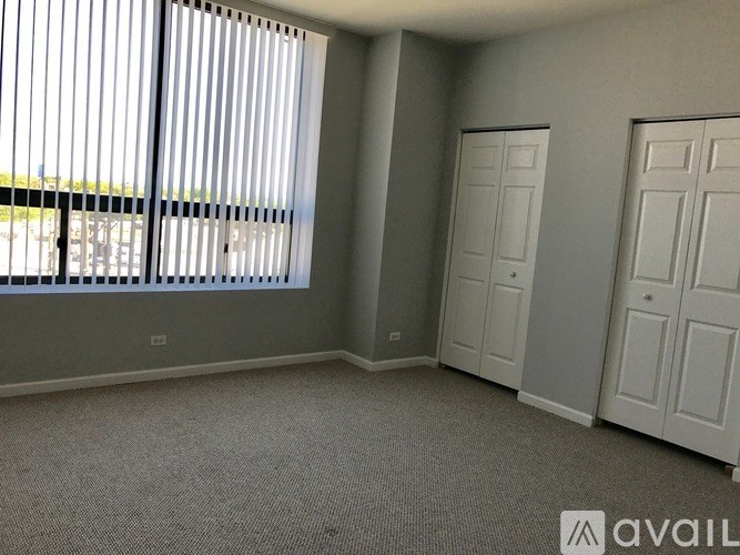 A room with grey walls, carpeted floor, and two white doors.