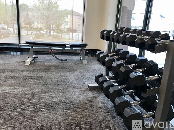 A gym with a bench and a rack of dumbbells.