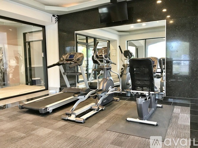 A gym with treadmills, elliptical machines, and other exercise equipment.