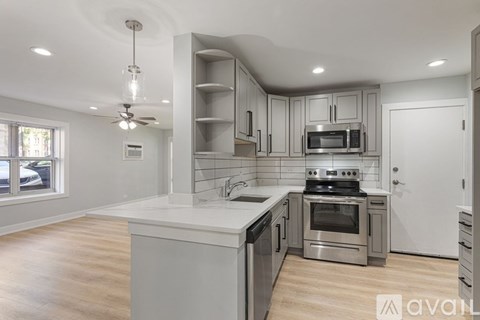 A modern kitchen with stainless steel appliances and wooden floors.