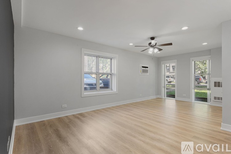 A spacious room with a ceiling fan and wooden flooring.