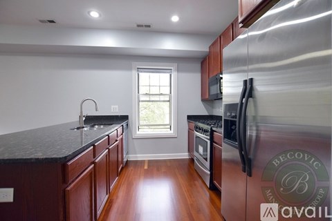 A kitchen with dark wood cabinets and stainless steel appliances.