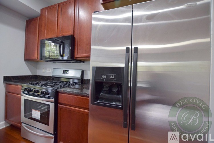 A kitchen with a stainless steel refrigerator, oven, and microwave.