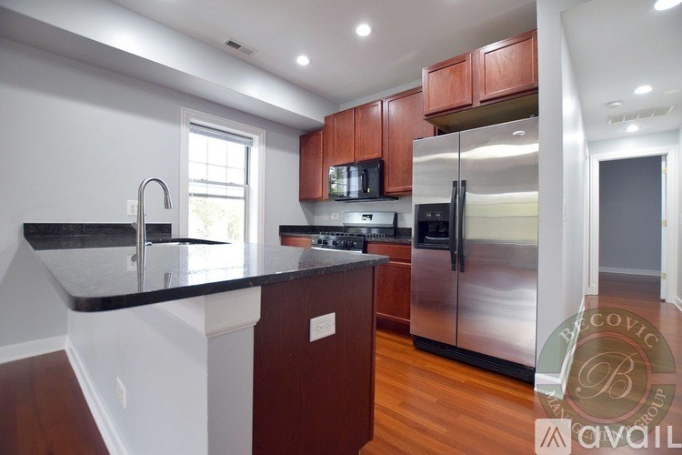 A kitchen with wooden cabinets and a black countertop.