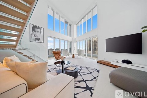 A living room with a couch, a coffee table, and a television.