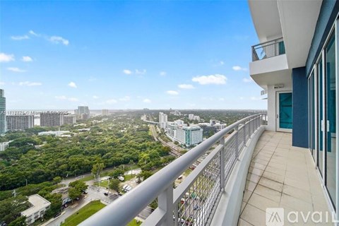 A balcony overlooks a cityscape with greenery and buildings.