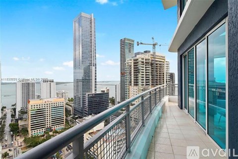 A balcony overlooks a cityscape with a view of the water.
