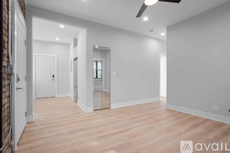 A spacious room with wooden flooring and white walls.