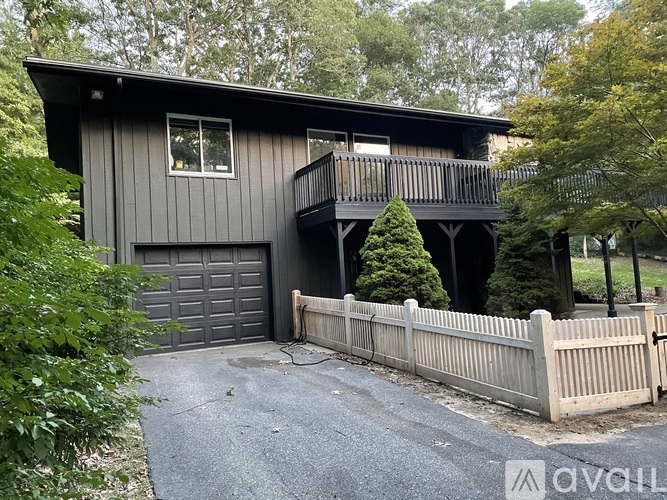A house with a grey garage door and a wooden fence.