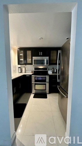 A kitchen with black cabinets and appliances is shown.