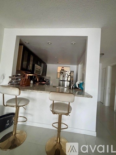 A kitchen with a bar stool in front of it.