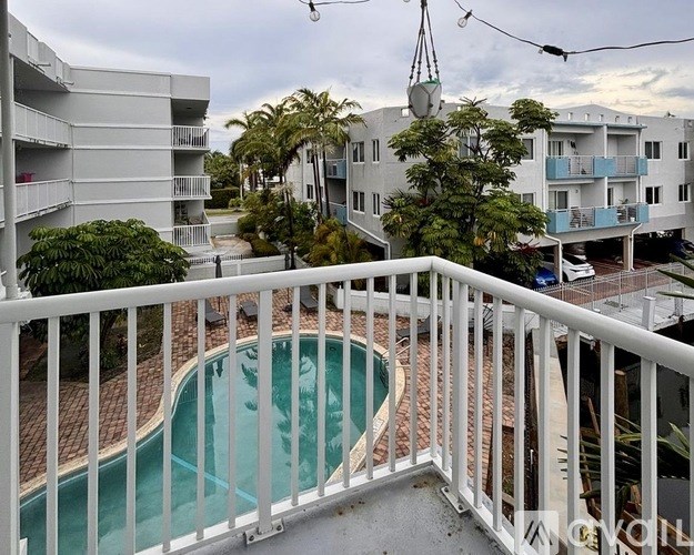 A balcony with a pool and apartment buildings in the background.