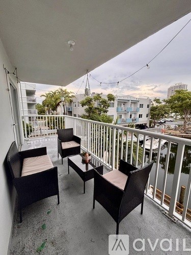 A balcony with two chairs and a table.
