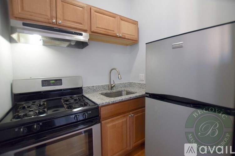 A kitchen with a stove, sink, and refrigerator.