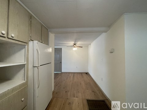 A kitchen with a white refrigerator and wooden floors.