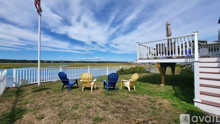 A white deck with chairs and an American flag on a sunny day.