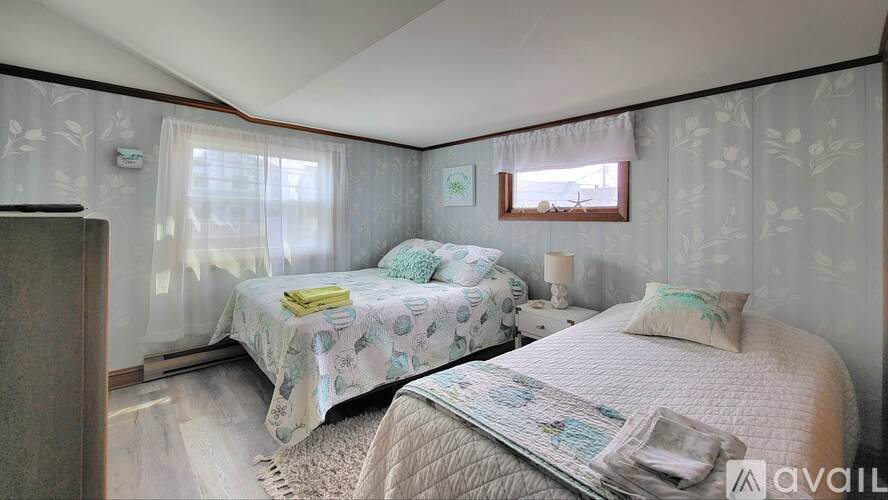 A bedroom with two beds and a dresser.