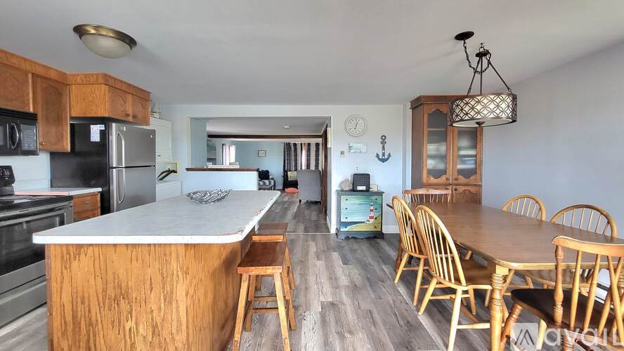 A kitchen with wooden cabinets and a wooden island with a bar stool.