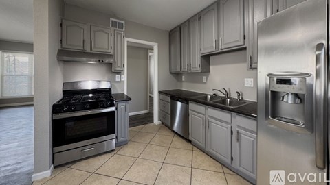 A kitchen with a stove, sink, and refrigerator.