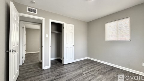 A room with a grey wall and a window with blinds.