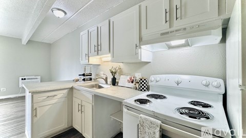 A white kitchen with a stove and sink.