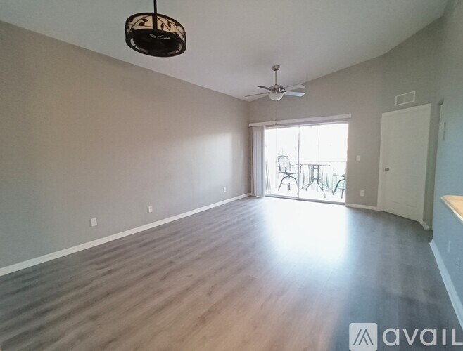 A room with a ceiling fan and a window with a table and chairs outside.