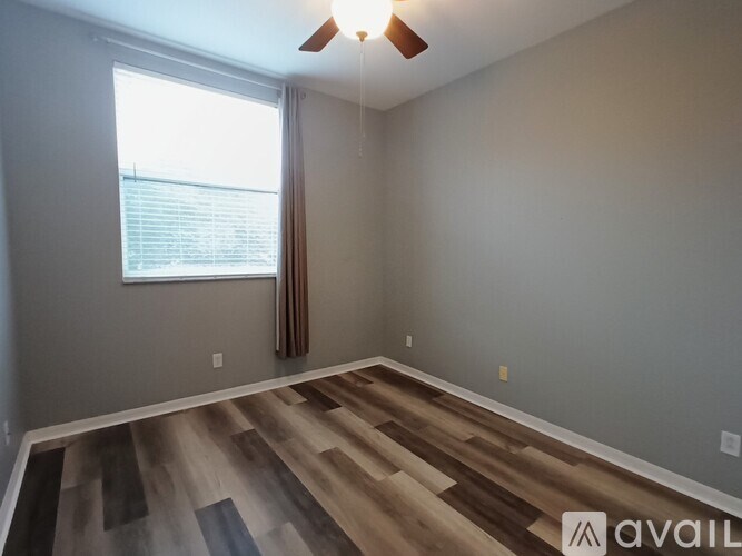 A room with wooden flooring and a ceiling fan.