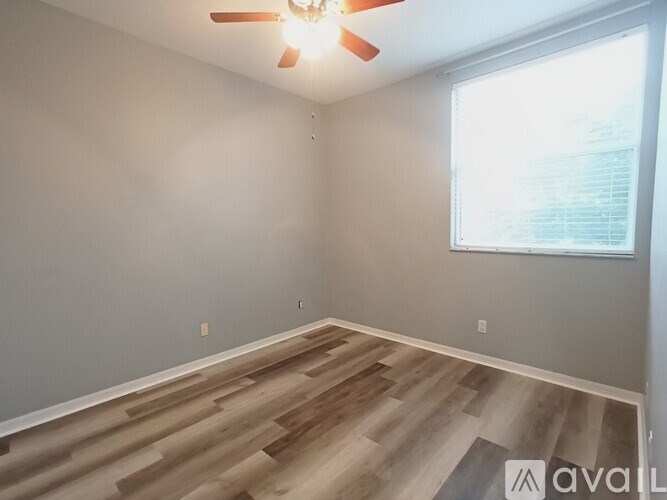 A room with wooden flooring and a ceiling fan.