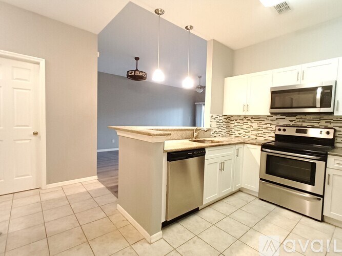 A kitchen with a white counter and stainless steel appliances.