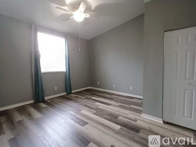 A room with a ceiling fan and a door.