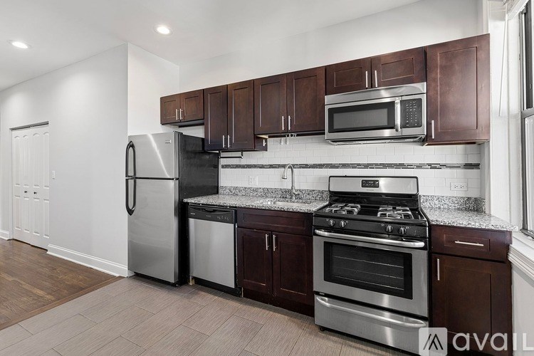 A kitchen with brown cabinets and stainless steel appliances.