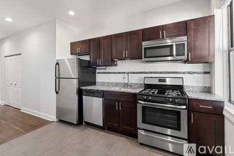 A kitchen with brown cabinets and stainless steel appliances.