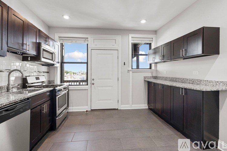 A kitchen with dark brown cabinets and a white door.