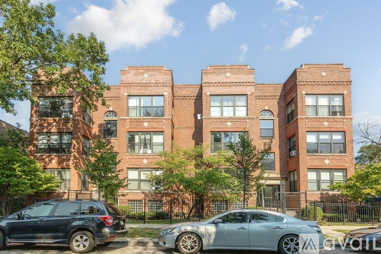 A large red brick building with a black fence in front.