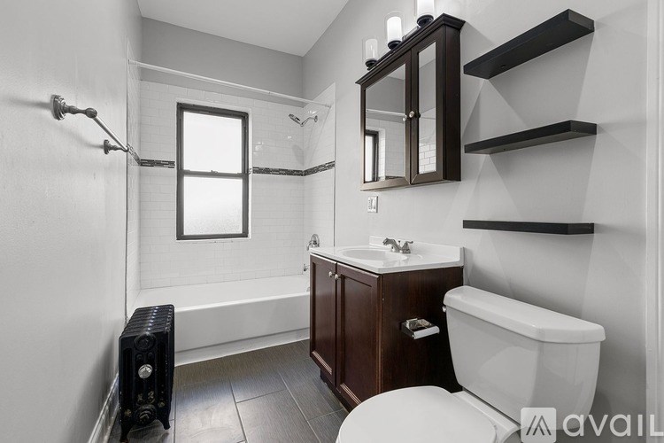 A bathroom with a white tub, sink, and toilet.