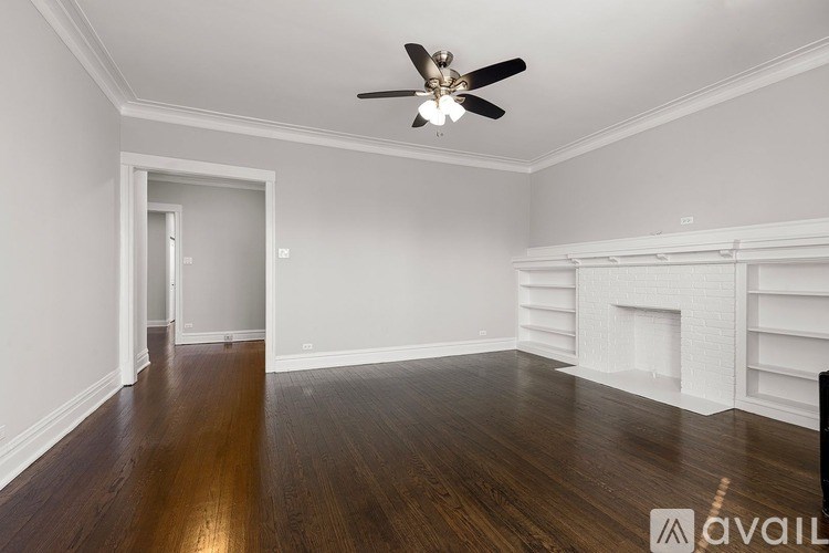 A room with a fireplace and wood flooring.