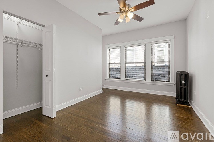A room with a ceiling fan and a window with blinds.