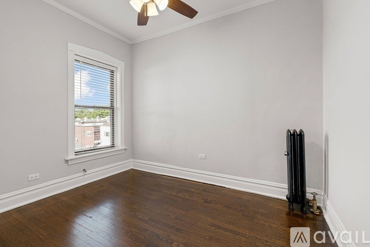 A room with a window and a fan on the ceiling.